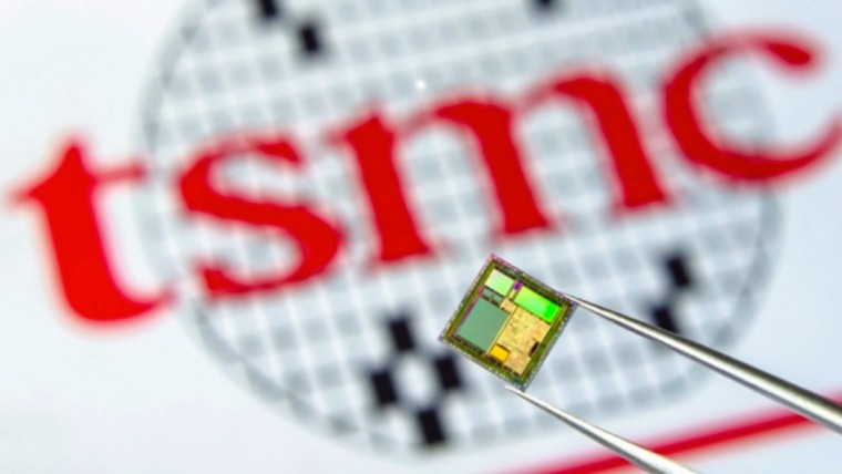 tweezers holding a microchip over the TSMC logo