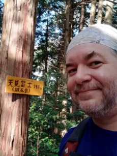 David Kawabata, smiling, on a hike in a forest in Japan
