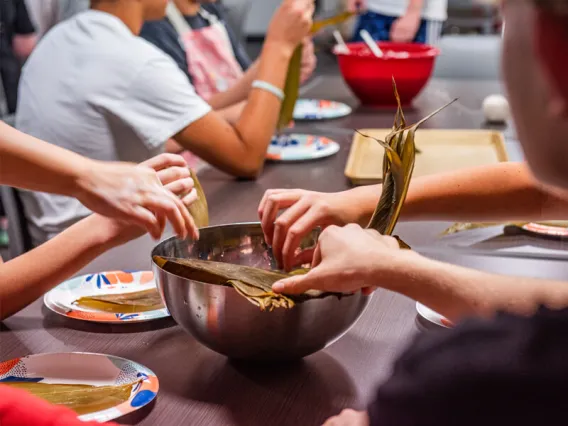 Closeup of a bowl on the table with student hands