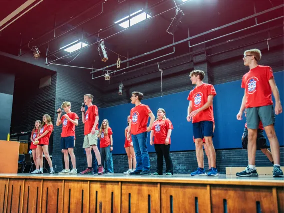 Kids on stage speaking to an audience