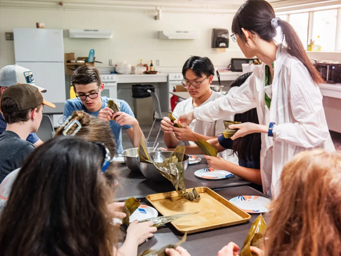 Professor working with group of kids in the kitchen at summer camp